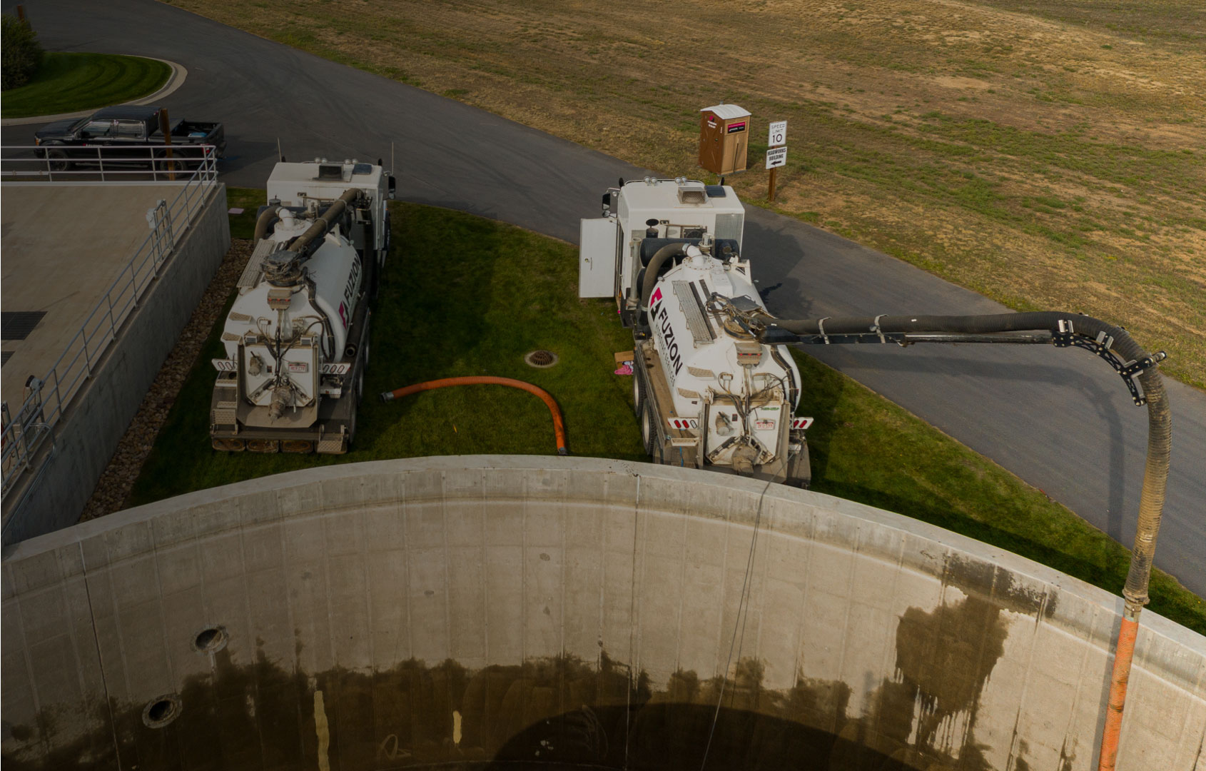 Fuzion Hydrovac trucks positioned over the containment tank during system close-out.
