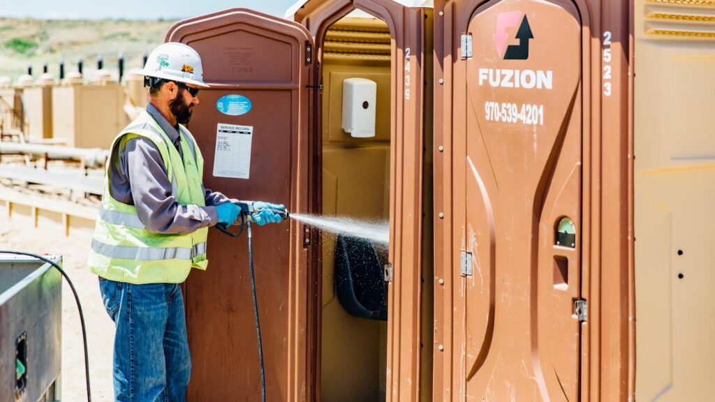 Fuzion Porta-Potties being cleaned by one of Fuzion’s crew.