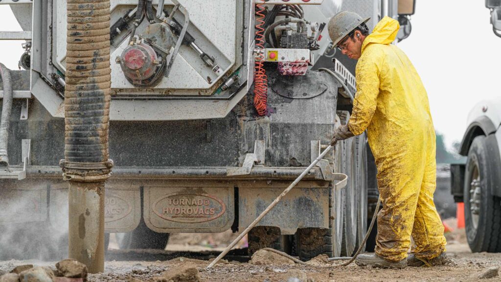 Hydrovac operator hydro trenching to locate utilities.