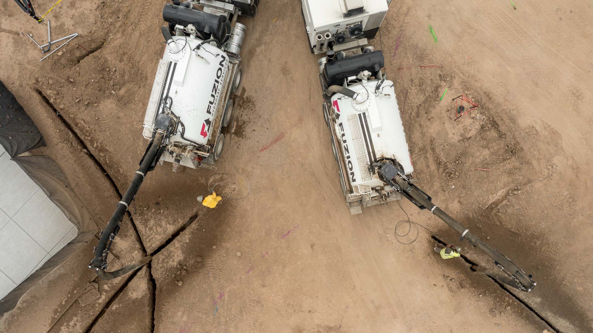 Birds’ eye view of hyrdrovac trucks digging trenches.