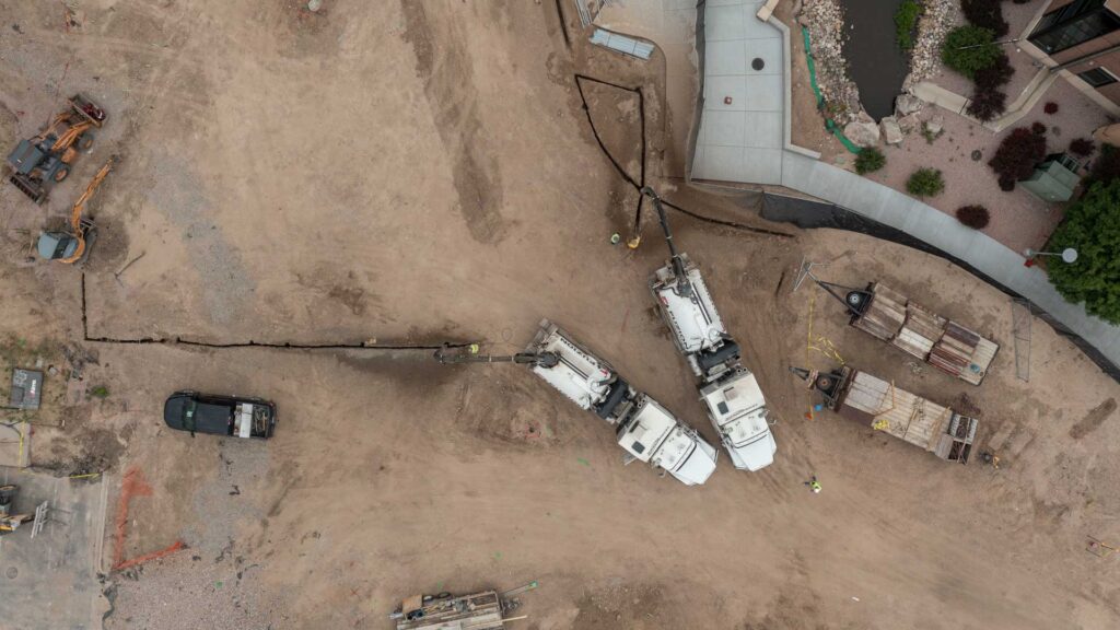 Two hydrovac trucks work to excavate and remove debris from the construction site.