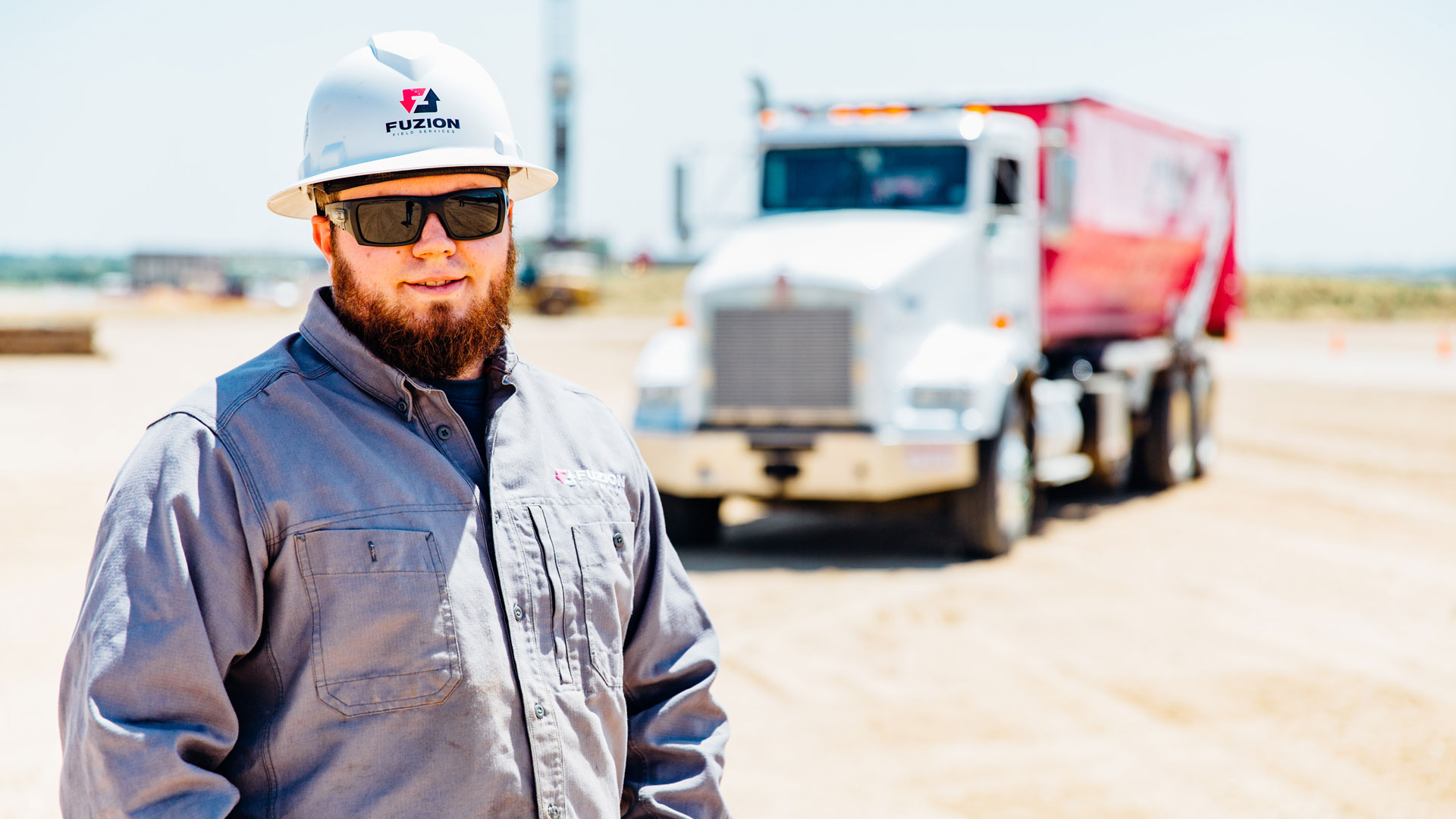 An image of a Fuzion employee in a field, following Waste Management Dumpster Rules.