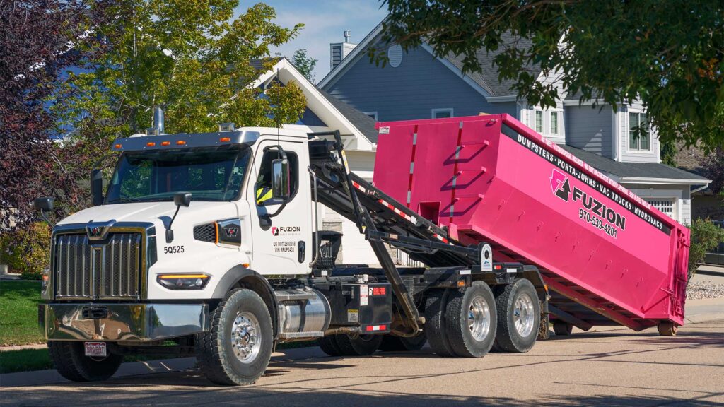 A Fuzion eco-friendly dumpster being picked up.