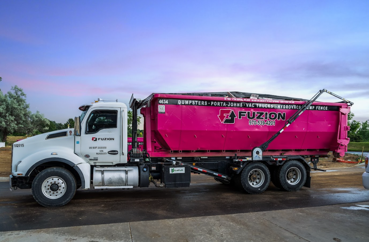 Roll off dumpster truck used for foreclosure clean outs at a residential property.