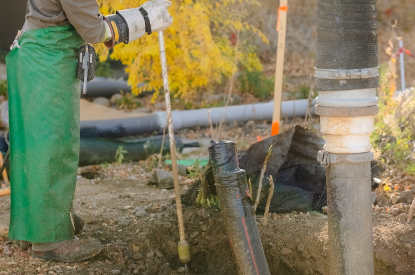 Fuzion employee using hydrojetting equipment as a clogged drain solution for an underground utility line.