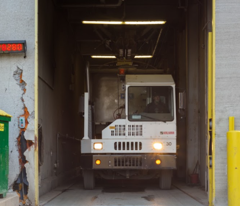 Garbage truck exiting a waste facility, illustrating what is organic waste during collection and processing.