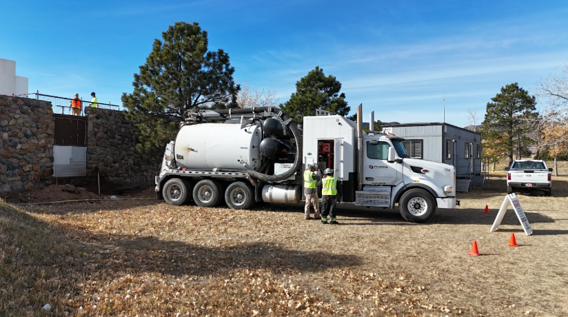 Vacuum truck and crew on site demonstrating hydrojetting vs snaking for sewer and drain maintenance.
