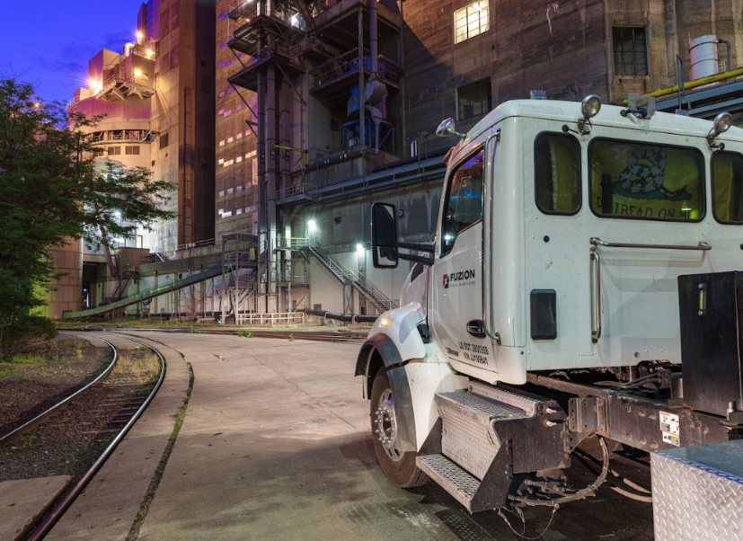 Fuzion truck on site for industrial water tank cleaning at a large manufacturing facility.