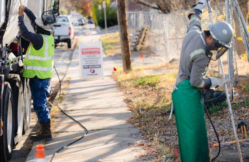Fuzion employees using hydrojetting equipment as a clogged drain solution with professional safety controls on site.