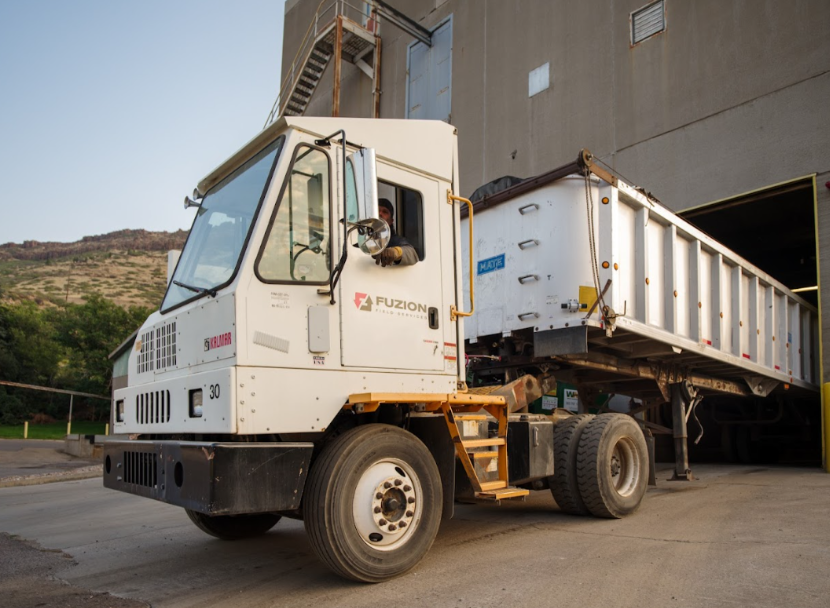 Truck hauling organic materials at an industrial facility as part of composting waste management operations.