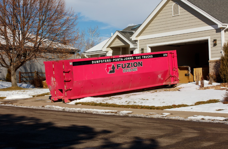 Pink Fuzion dumpster in driveway with risk of damage.