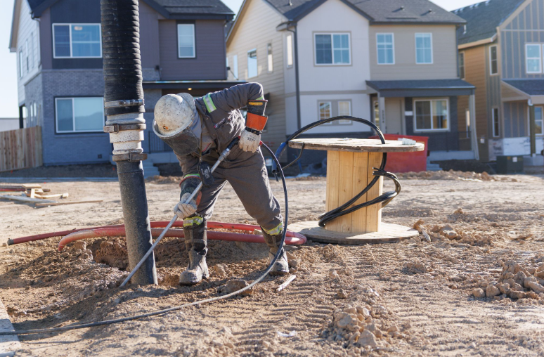 Fuzion technician using a hydro jetting wand at a construction site.