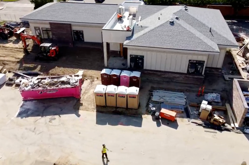 Fuzion roll-off dumpsters and portable toilets placed at a jobsite.