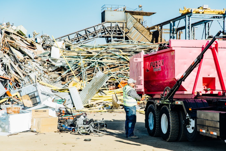 Fuzion roll-off dumpster being unloaded at a recycling and scrap processing facility.
