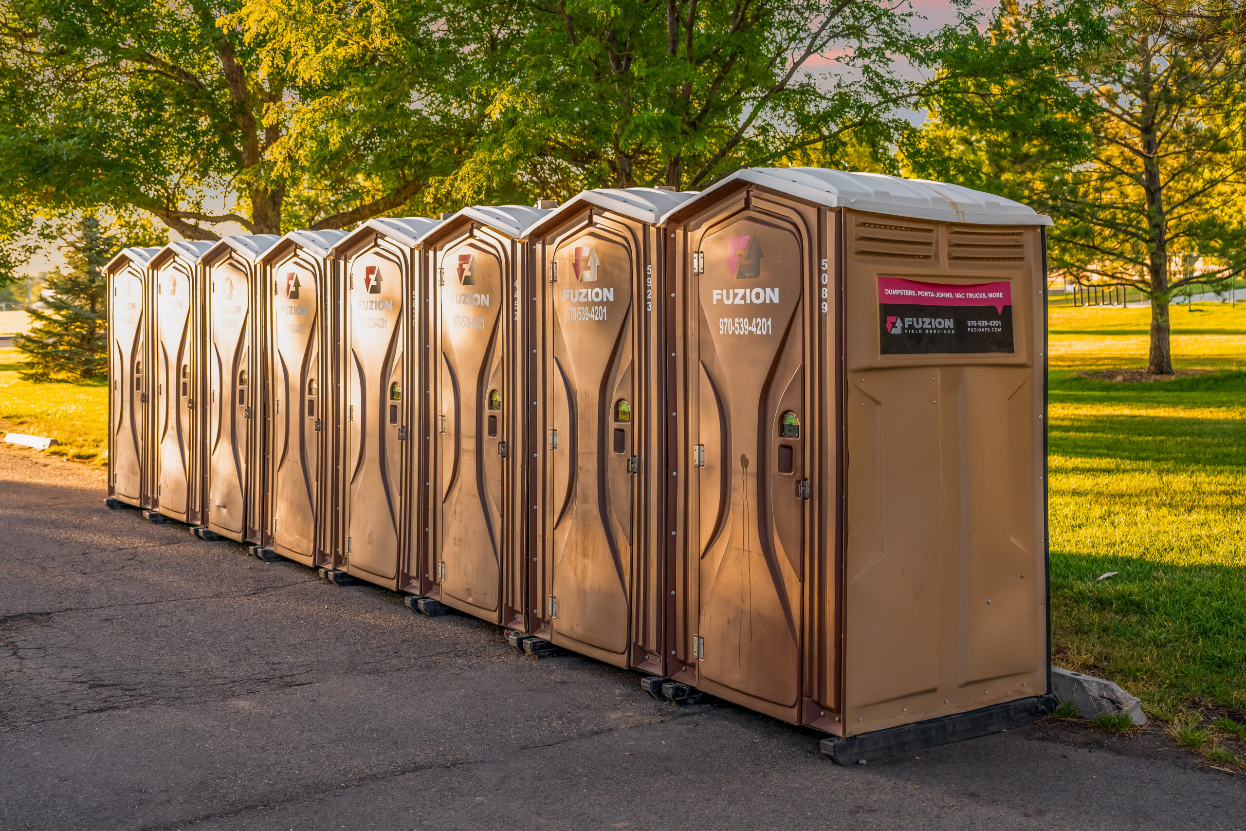 Row of portable restrooms set up for an outdoor event.