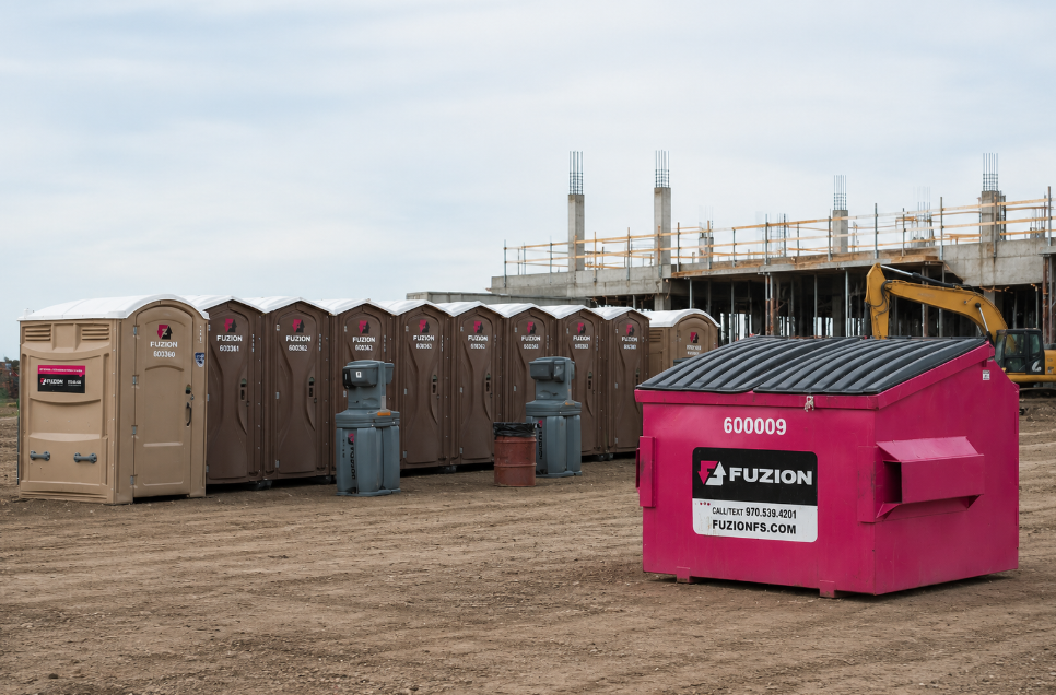 Fuzion dumpsters and portable restrooms at an active construction site.