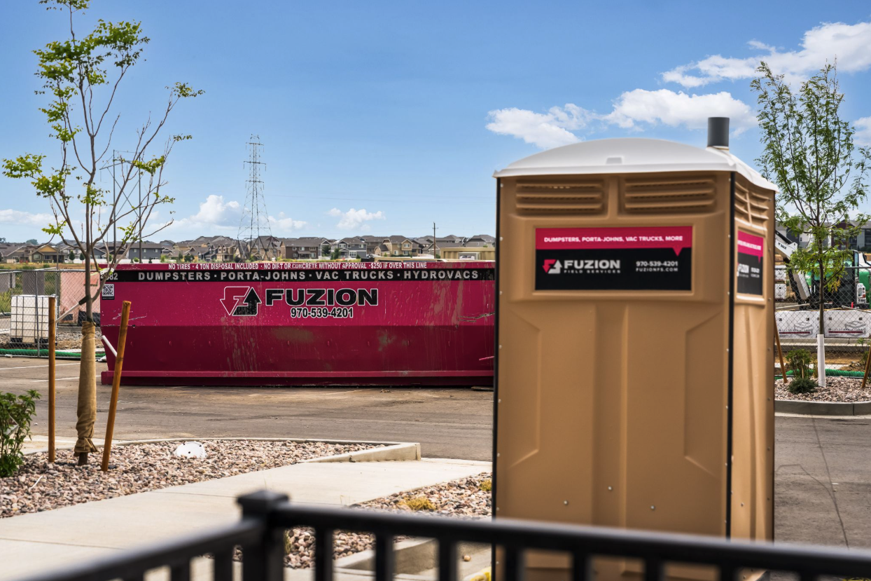 Fuzion porta-john and dumpster placed at an active residential construction site.
